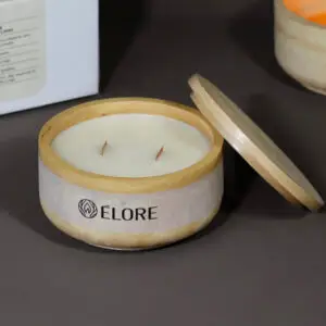 Vela Élore Éclat aberta com tampa ao lado, mostrando dois pavios e embalagem elegante.