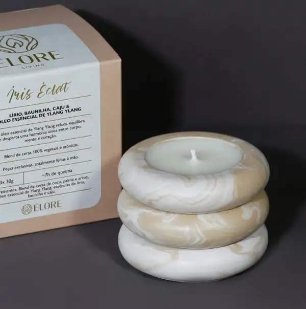 Kit Íris Éclat com 3 velas pequenas empilhadas e caixa kraft ao fundo.