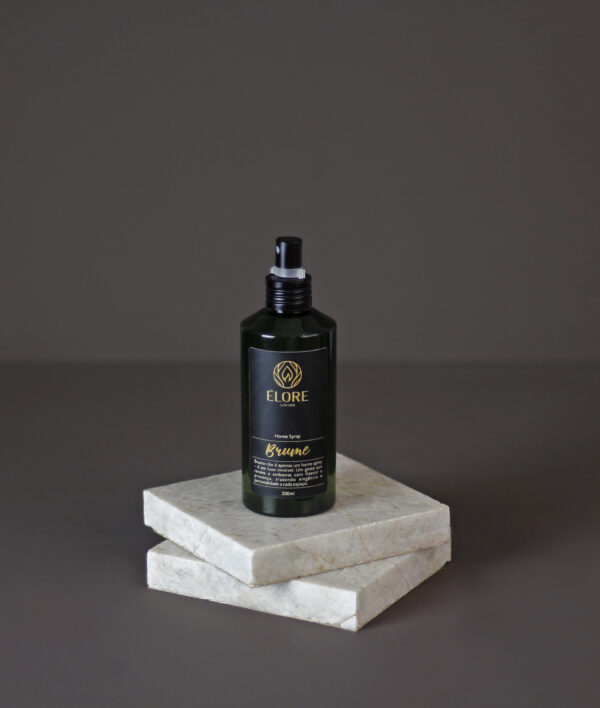 Home Spray Élore Brume sobre pedras de mármore, com fundo escuro elegante.